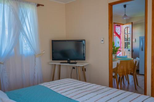 a bedroom with a bed and a flat screen tv at Cabañas Maihue in La Serena