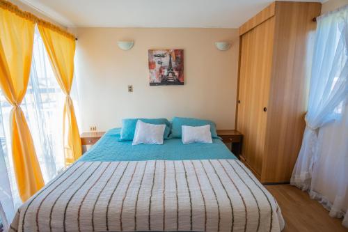 a bedroom with a large bed with blue sheets at Cabañas Maihue in La Serena