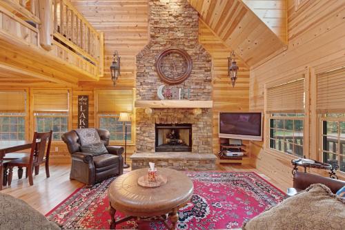 a living room with a stone fireplace and a tv at Kingfisher Cove Cabin 2 in Saugatuck