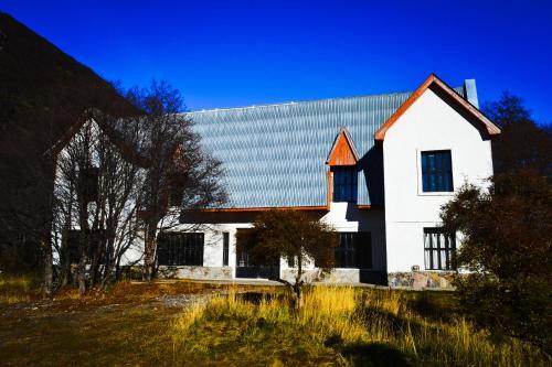 una casa blanca con techo de gambrel en Hostería Punta Sur en Lago del Desierto en El Chaltén