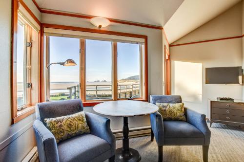 キャノンビーチにあるザ ウェイブスの椅子2脚、テーブル、窓が備わる客室です。