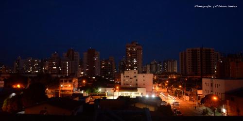 a city lit up at night with buildings at Vila Suítes Coliving in Vila Velha