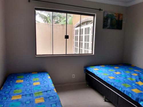 聖佩德羅－達阿爾德亞的住宿－Casa Temporada Balneario de Sao Pedro Cabo Frio，一间卧室设有两张床和窗户。