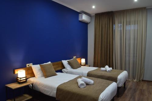 a hotel room with two beds and a blue wall at Taba Hall Boutique Hotel in Akhaltsikhe