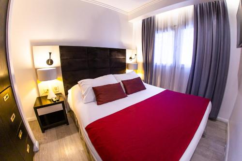 a bedroom with a large bed with a red blanket at Hotel Sommelier Agustinas in Santiago