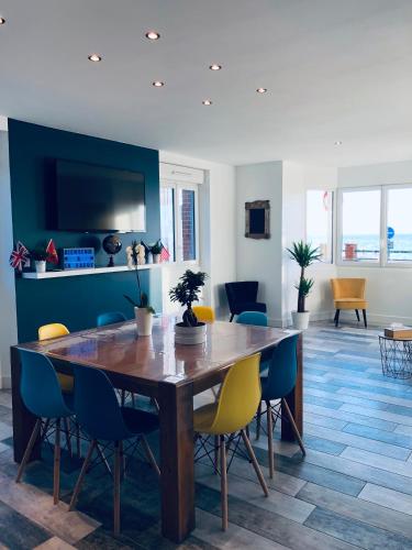 une salle à manger avec une table et des chaises en bois dans l'établissement Gîte « La Vague » 8-10 pers, à Grandcamp-Maisy