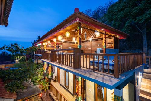a house with a wrap around deck at night at Breeze Villa in Nusa Lembongan