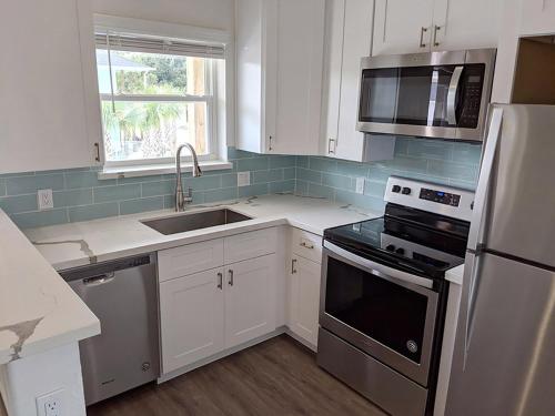 a kitchen with white cabinets and a stainless steel appliances at Seaside RV resort in Seabrook