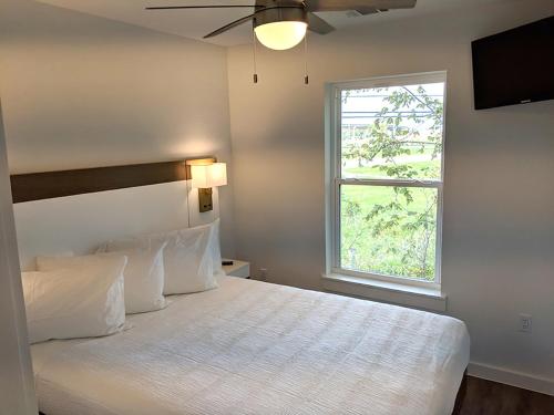 a bedroom with a bed with a ceiling fan and a window at Seaside RV resort in Seabrook