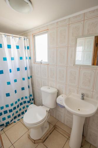 a bathroom with a toilet and a sink at Cabañas Maihue in La Serena