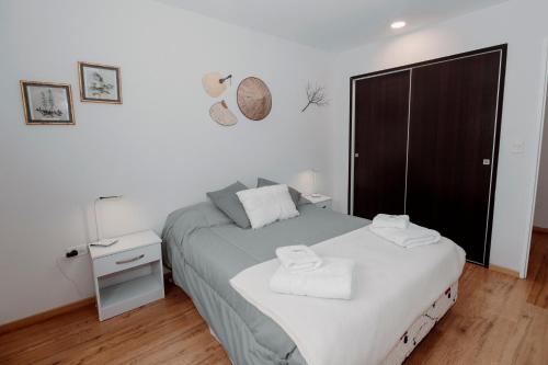 Un dormitorio con una cama con dos toallas encima. en Ushuaia Homes Martial Apartments, en Ushuaia