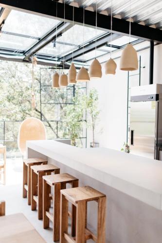 une cuisine avec un comptoir blanc et des tabourets en bois dans l'établissement Casa Pancha, à Mexico