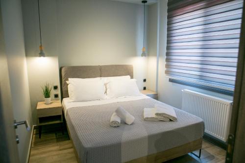 een slaapkamer met een bed met twee handdoeken erop bij STS EIGHT 7 New Luxury Apartment in Thessaloniki