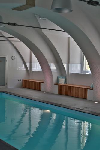 an indoor swimming pool with blue water in a building at Chateau Herálec Boutique Hotel & Spa by L'Occitane in Herálec