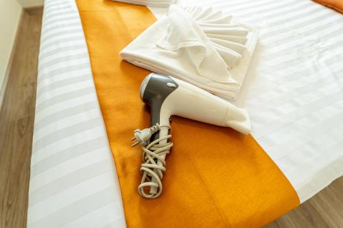 a hair dryer sitting on top of a bed at ZcapeX2 in Bang Tao Beach