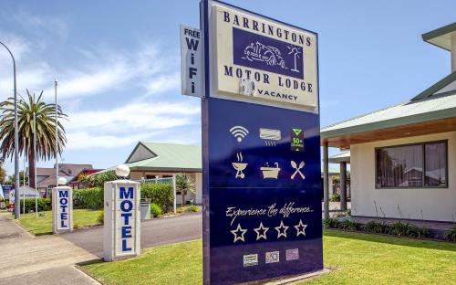a sign for a motor lodge in front of a house at Barringtons Motor Lodge in Whakatane