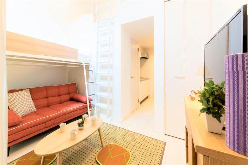 una sala de estar con un sofá y una mesa en TRIP POD TAKASAGO A, en Fukuoka