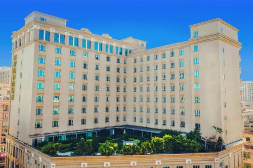 a large tan building with trees in front of it at 东莞君兰酒店 Grand land hotel in Dongguan