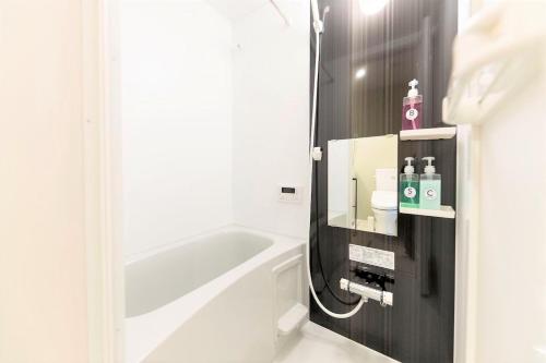 a bathroom with a bath tub and a sink at TRIP POD TOJIN-MACHI A in Fukuoka