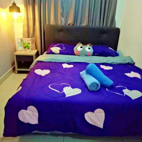 a bed with a purple comforter with hearts on it at Desaru Cosy Homestay - near WaterPark, Beach, Rapid -Wifi, TVbox, Steamboat, BBQ Available in Desaru