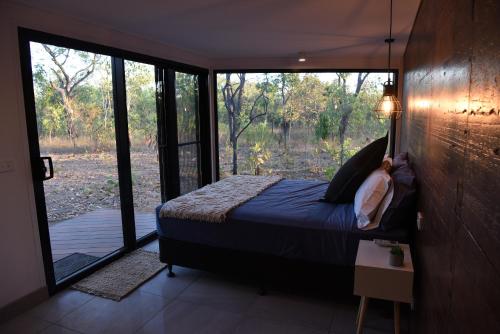 a bedroom with a bed and a large window at Hideaway Litchfield in Rakula