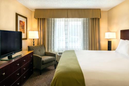 a hotel room with a bed and a television at Holiday Inn Express & Suites Sandy - South Salt Lake City by IHG in Sandy