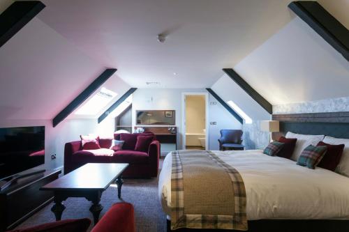 a bedroom with a bed and a couch and a table at The White Hart Hotel Wetherspoon in Okehampton