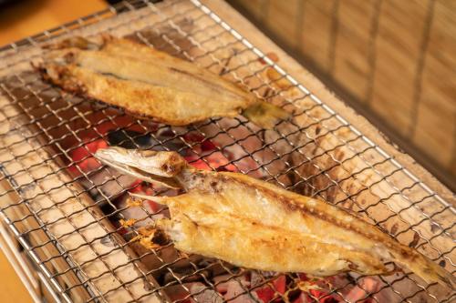 two pieces of fish cooking on a grill at Imigre in Himi