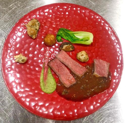 a red plate of food with meat and broccoli at Imigre in Himi