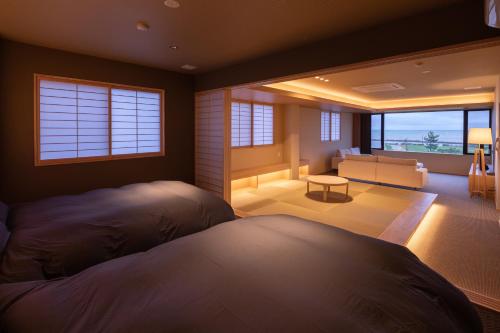 a bedroom with two beds and a living room at Imigre in Himi