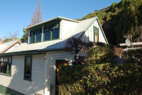 a white house with a hill in the background at Shakespeare Cottage in Napier