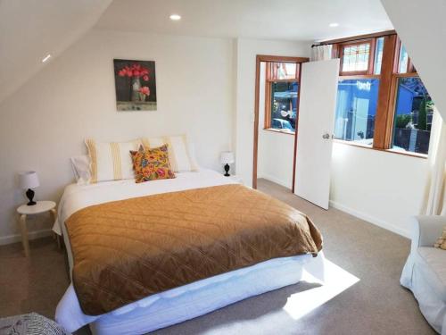 Un dormitorio con una cama grande y una ventana en Shakespeare Cottage, en Napier