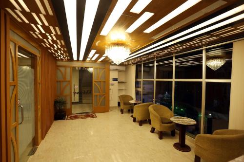 an office lobby with chairs and tables and windows at The Grand Hotel BD in Sylhet