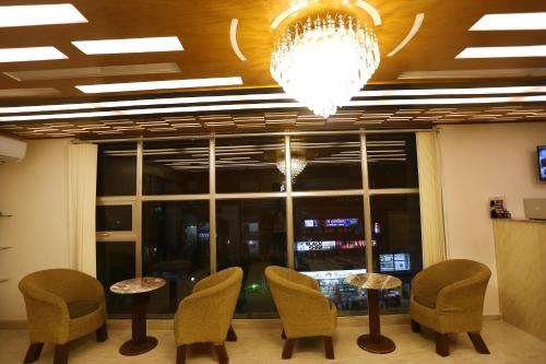 a room with chairs and tables and a chandelier at The Grand Hotel BD in Sylhet