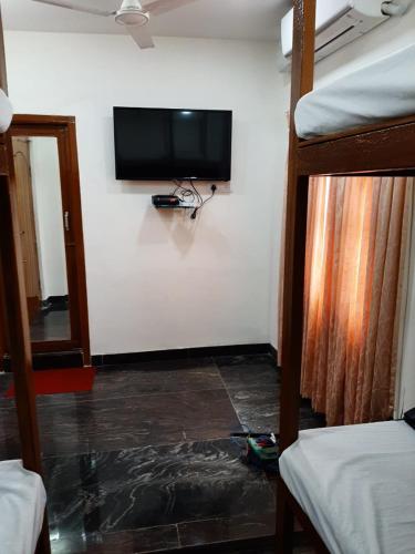 a room with a flat screen tv on a wall at BAY INN in Chennai