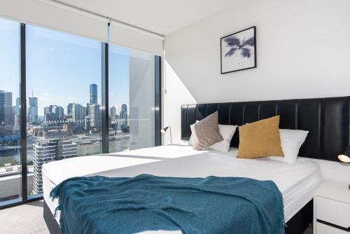 a bedroom with a large bed with a large window at Serain Residences On Merivale Street in Brisbane