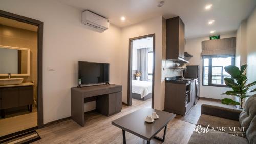 a living room with a couch and a tv in a room at iRest Apartment Vinh Yen in Yen