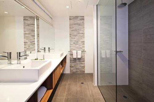 Best Western Plus Ballarat Suites في بالارات: حمام مع مغسلتين ودش