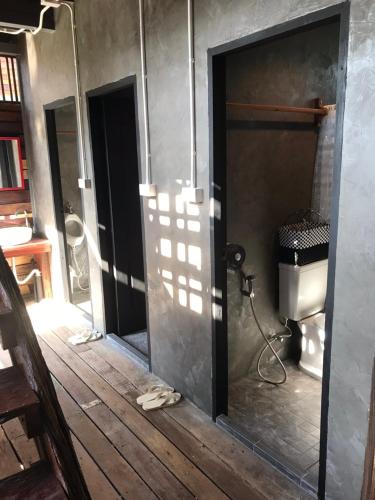 an open bathroom with a toilet and a door at BAANYA HOMESTAY Ko Kret in Nonthaburi