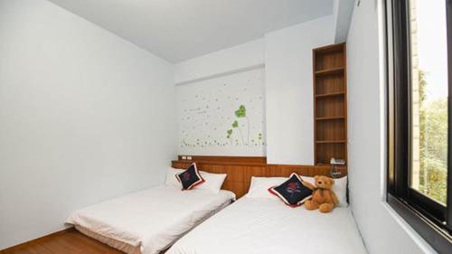 a small bedroom with two beds and a teddy bear at Green Garden in Xiaoliuqiu
