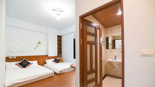 a hotel room with two beds and a sink at Green Garden in Xiaoliuqiu