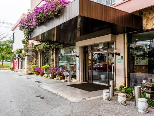 a store front with potted plants and flowers at Crown Hotel Okinawa in Okinawa City