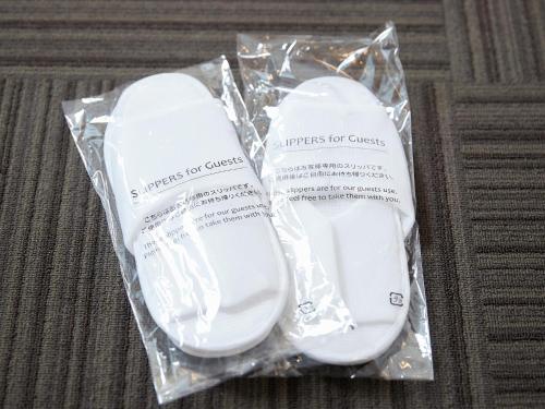 two white shoes in a plastic bag on a table at Crown Hotel Okinawa in Okinawa City