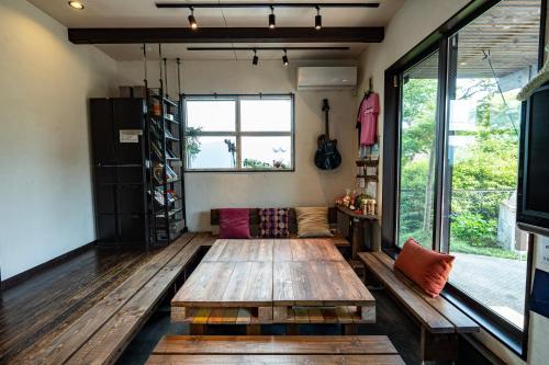 uma sala de estar com uma mesa de madeira e uma janela em Sendai Guest House UMEBACHI em Sendai