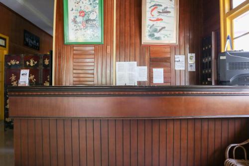 a counter in a restaurant with signs on the wall at Wisma Mutiara in Padang