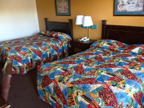two beds sitting next to each other in a hotel room at Heritage Inn Grand Prairie in Grand Prairie
