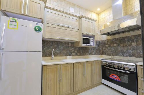 a kitchen with a white refrigerator and a microwave at Al Saraya Chalet Families Only in Buraydah