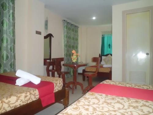 a hotel room with two beds and a table and a desk at Bora Sky Hotel in Boracay