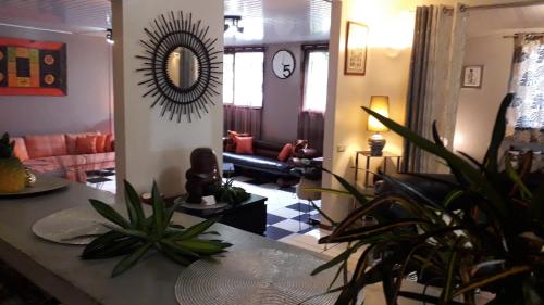 a living room with a couch and a table with plants at Fare D'hôtes Tutehau in Papeete