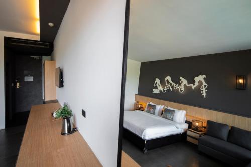 a bedroom with a bed and a couch at The VELO'S Hotel and Pumptrack in Aranyaprathet